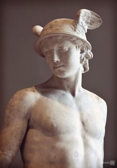 a statue with a hat on top of it's head and chest, in front of a gray background