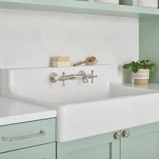 a kitchen with green cabinets and white sink