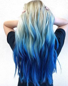 the back of a woman's head with blue and blonde hair in front of white wall