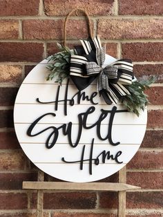 a sign that says the sweet home hanging on a brick wall