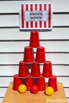 red cups stacked on top of each other in front of a sign that says knock down