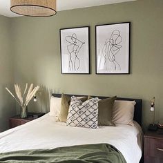 a bedroom with two pictures on the wall above the bed