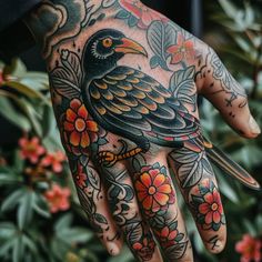 a person's hand with a bird on it and flowers all around the wrist