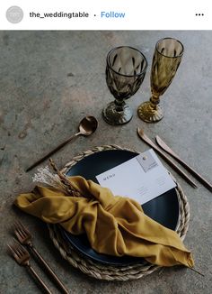 a plate with a napkin on top of it next to some silverware and glasses