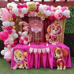 a pink and gold paw patrol birthday party with balloons, decorations and table cloths