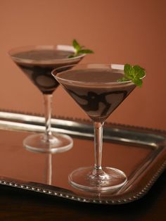 two chocolate martinis sitting on top of a metal tray