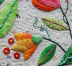 a close up of a piece of cloth with buttons on it and flowers in the background