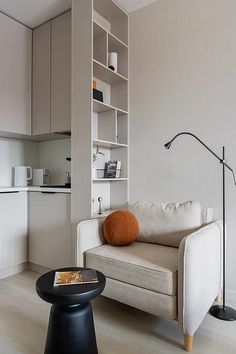 a living room filled with furniture and a white couch in front of a book shelf