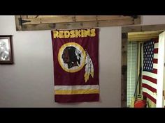 a washington football team flag hanging on the wall in a room with an american flag