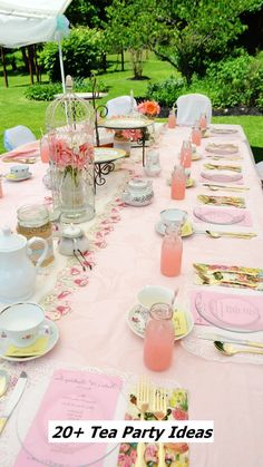 the table is set for tea party with pink napkins and place settings on it