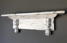 an old white wooden shelf on the wall