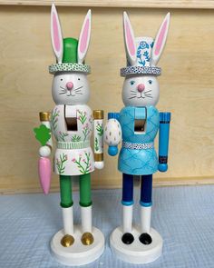 two rabbit figurines are standing next to each other