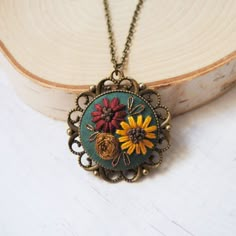 a close up of a necklace with flowers on it