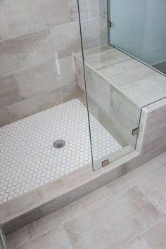 a walk in shower sitting next to a tiled floor