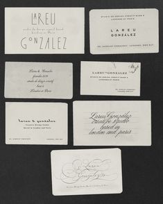 several different types of business cards on a black surface with some writing in the middle