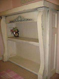 a white shelf with flowers on top in a room