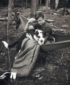 a man sitting in a hammock with his dog