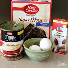 ingredients to make chocolate cake sitting on a counter next to a box of flour and eggs