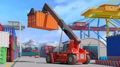 an orange crane is in the middle of a road with containers on either side and mountains in the background