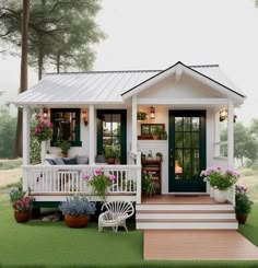 a small white house with green shutters and flowers on the front porch, along with potted plants