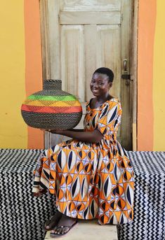 a woman sitting on a bench holding a basket