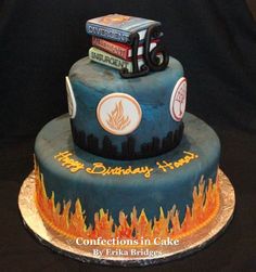 a three tiered cake with the number 65 on it's side and fire trucks on top