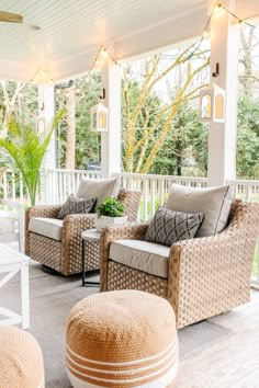 a porch with wicker furniture and lights on the ceiling is decorated in neutral colors