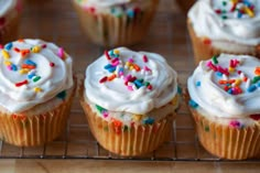 there are two cupcakes with white frosting and sprinkles on them