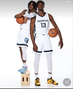 two basketball players posing for a photo with their arms around each other and one holding a basketball