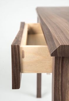 a close up of a wooden table with drawers on it's sides and one drawer open