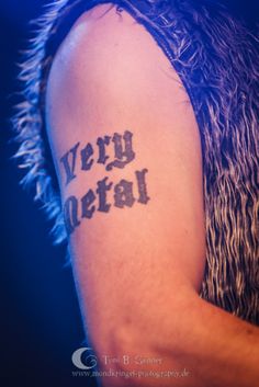 a close up of a person with a tattoo on their arm that says very metal