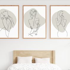 two framed art prints on the wall above a bed