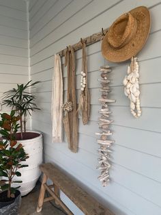 a hat hanging on the side of a wall next to a bench and potted plant