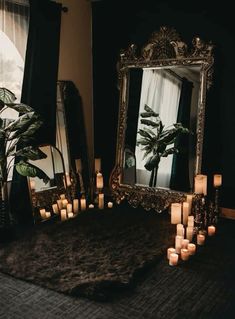 candles are lit in front of an ornate mirror