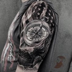 a man's arm with an eagle, compass and american flag tattoo on it