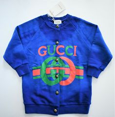 GUCCI KIDS Brand: GUCCI KIDS Product Size: 4 (Check measurements below) Main color: royal blue/multi Details: Loved for its lavish Italian styling, Gucci Kids is the go-to label for the next fashion-forward generation. This blue cotton logo print cardigan from Gucci Kids features a front button fastening, a signature interlocking CC logo and a tie-dye print. Fastened with decorative buttons.  Elasticized bottom hem and cuffs. Long sleeve Made in Italy Measurements: Shoulders: approx. 13.5~14 inc Gucci Cotton Sweatshirt With Logo, Gucci Blue Casual Sweater, Gucci Casual Blue Sweater, Casual Blue Gucci Sweater, Gucci Cotton Outerwear With Button Closure, Blue Gucci Cotton Outerwear, Blue Cotton Gucci Outerwear, Gucci Designer Cotton Outerwear, Gucci Blue Long Sleeve Sweater