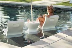 a woman sitting in a chair next to a pool