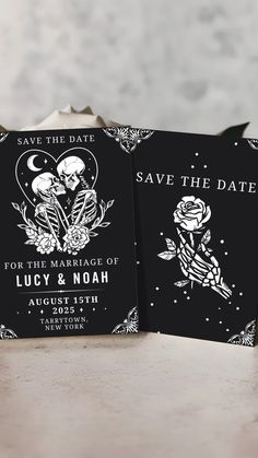 wedding save the date cards in black and white with skeleton illustrations on them, sitting on a table