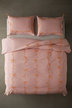 an orange and white bed with two pillows