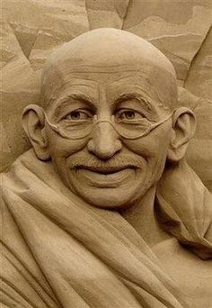 a statue of a man with glasses and a smile on his face is shown in sepia