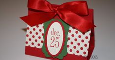 a red and white box with a bow on it that says december 25, decorated with polka dots