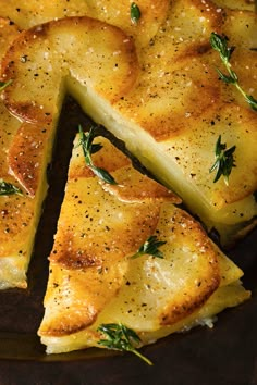 slices of bread with herbs and seasoning on them sitting in a pan, ready to be eaten