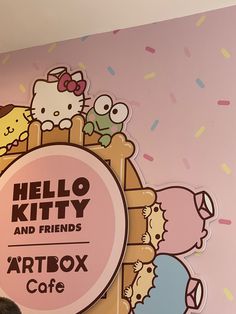 the hello kitty and friends artbox cafe is located in front of a pink wall with sprinkles