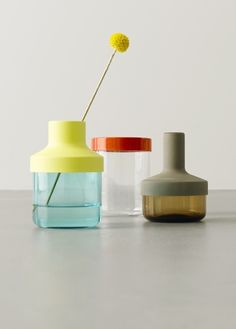 three vases with flowers in them sitting on a counter top next to each other