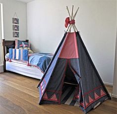 a teepee tent sitting on top of a wooden floor