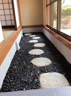 a room that has some rocks on the ground in front of it and a window