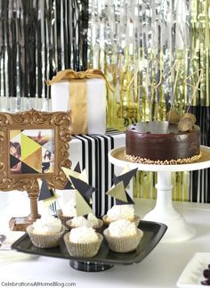 a table topped with cakes and cupcakes next to a cake plate covered in frosting