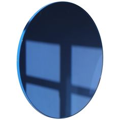 a round mirror with a cross on it's side in front of a white background