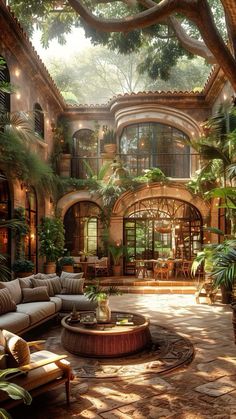 a living room filled with lots of furniture and plants on top of a stone floor