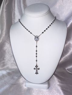 The Rosary Lariat is the perfect addition to any jewelry stack! This 24 inch lariet has a gothic inspired cubic zirconia cross. Choose from either silver (rhodium filled) or 18k gold (filled). No matter how you wear it, this necklace is sure to make a statement! Cross Necklace Long, Dark Jewellery Aesthetic, Gothic Rosary Necklace, Gothic Jewelry With Cross Pendant And Adjustable Chain, Gothic Jewelry With Adjustable Chain And Cross Pendant, Adjustable Gothic Cross Pendant Jewelry, Elegant Sterling Silver Rosary With Cross, Elegant Adjustable Silver Cross Necklace, Gothic Cross Jewelry With Adjustable Chain